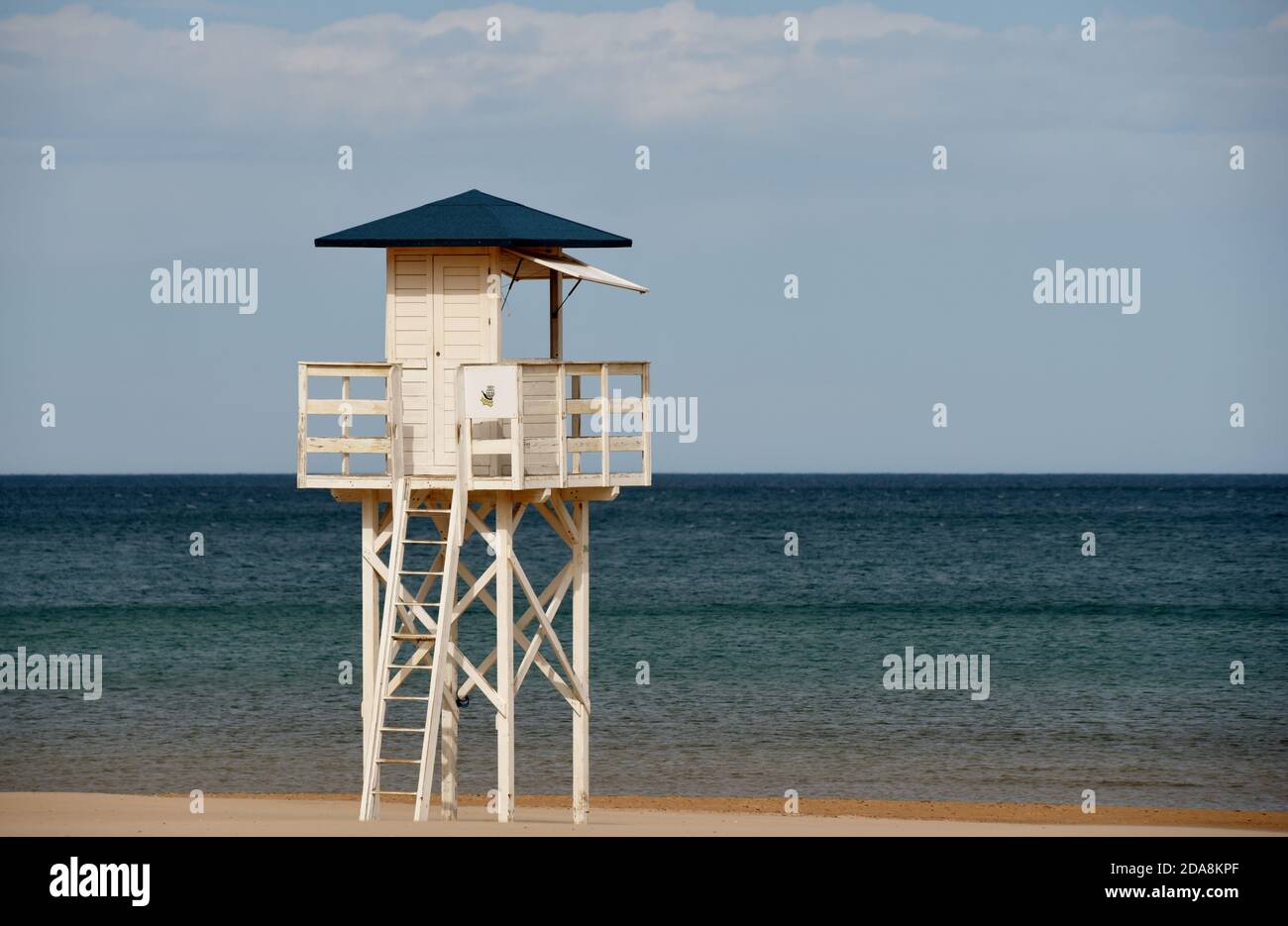 A watchtower looks out over a perfectly calm Mediterranean sea in this photo taken on a still spring day in Spain Stock Photo