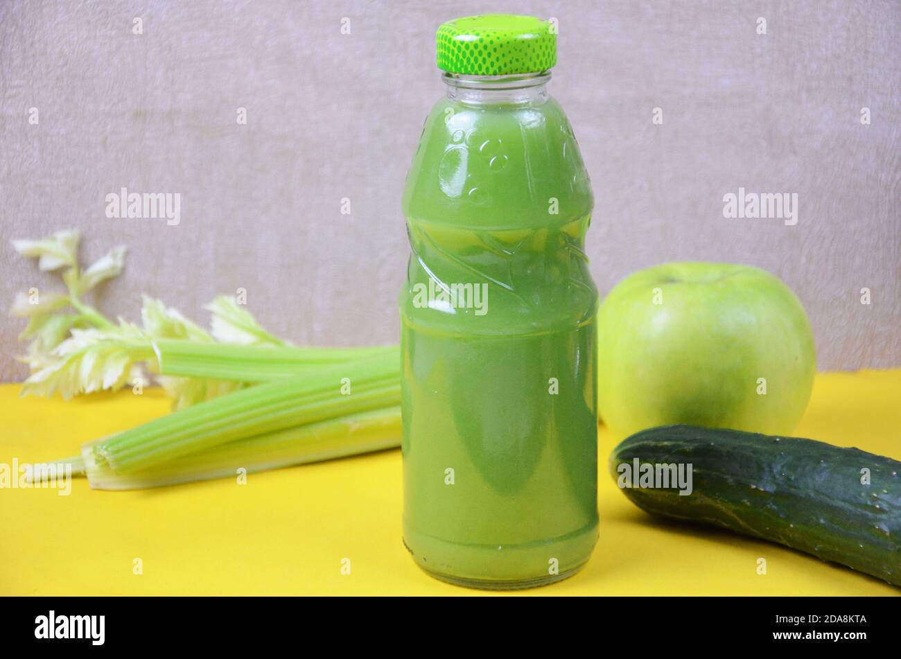 Fresh Green Juice with apple, cucumber, celery on yellow background