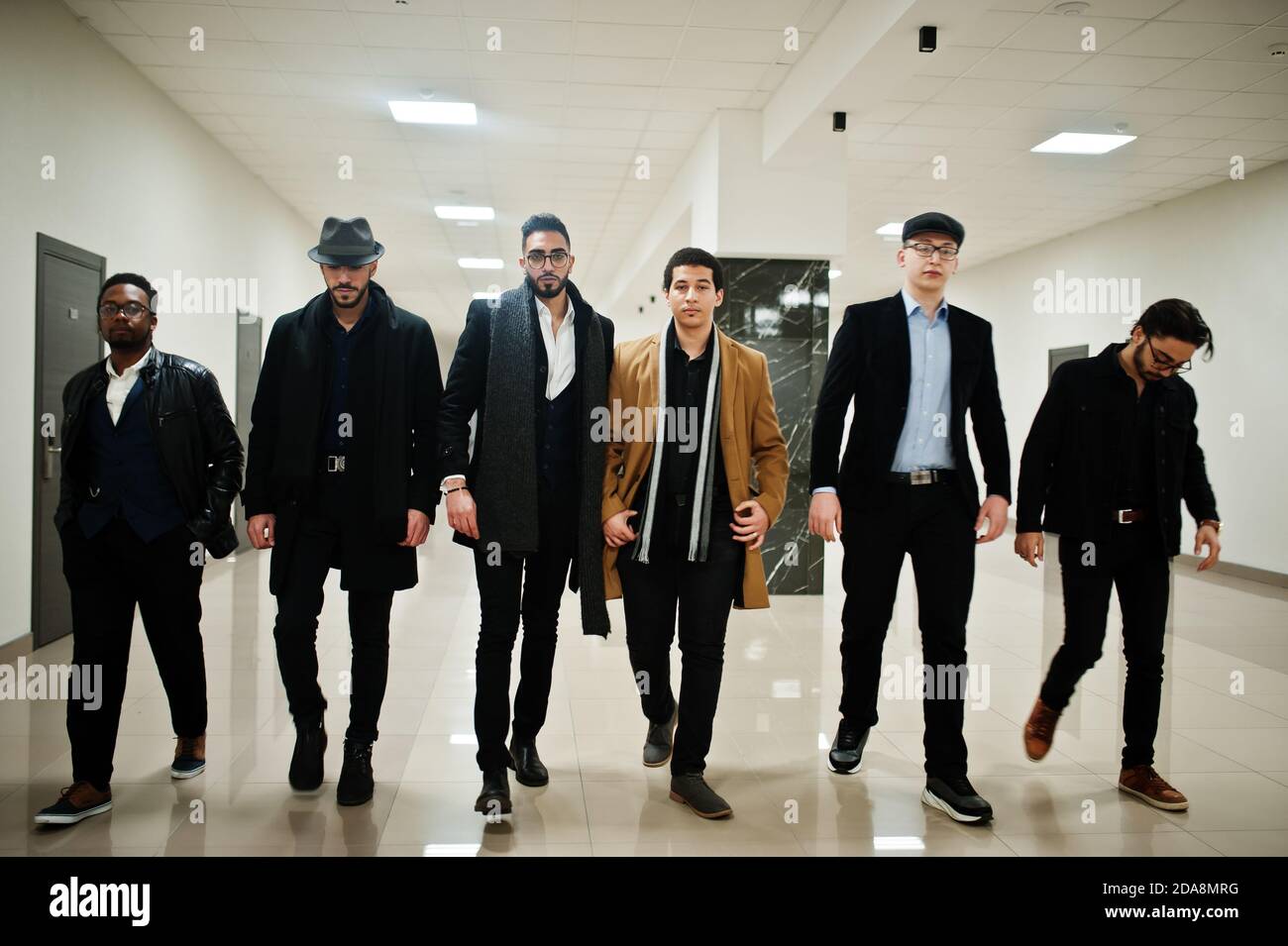 Group of handsome retro well-dressed man gangsters indoor at hotel. Multiethnic male bachelor mafia. Stock Photo