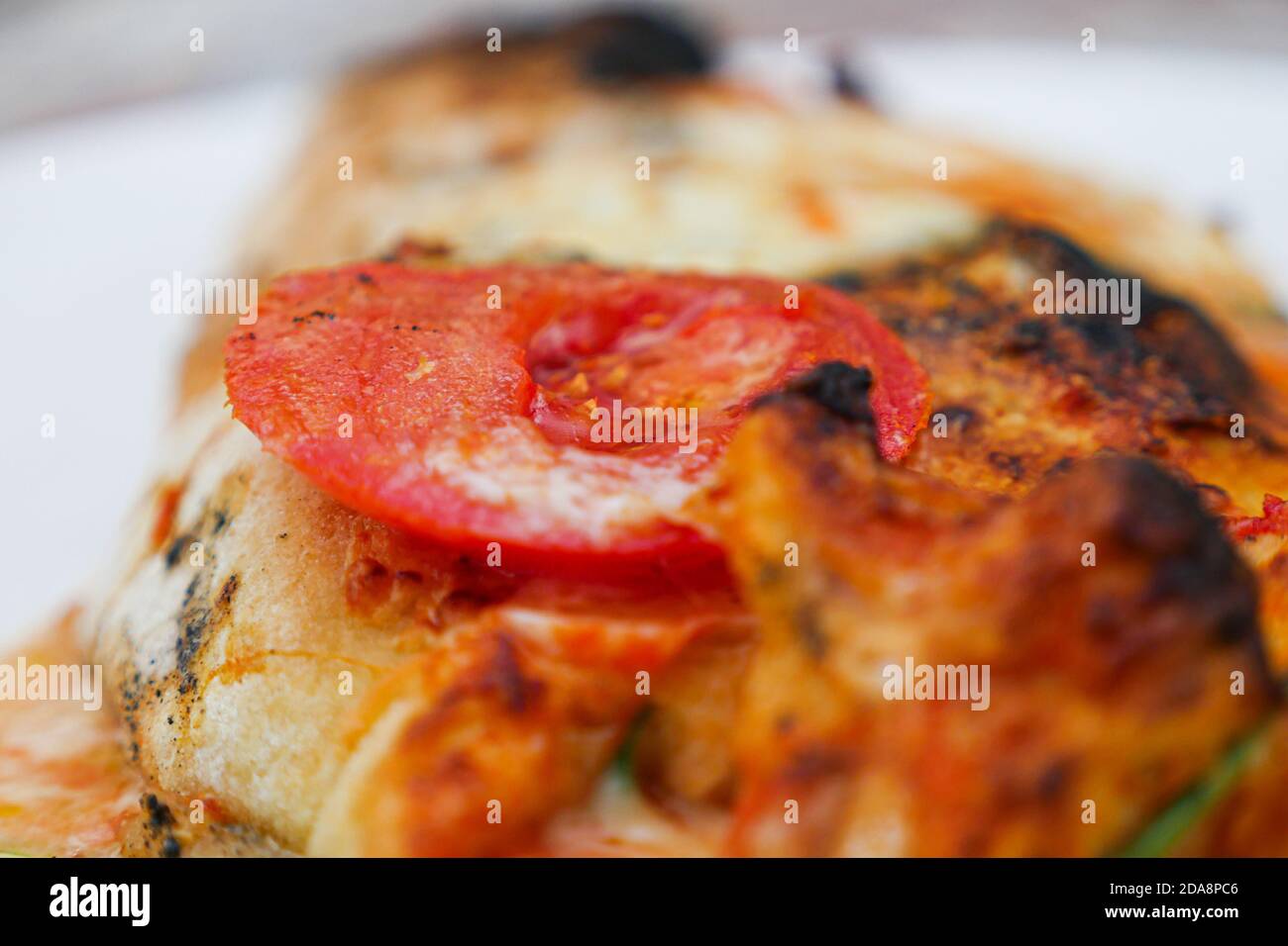 Cooked pepperoni slice on dough piece. Extreme close up Stock Photo Alamy