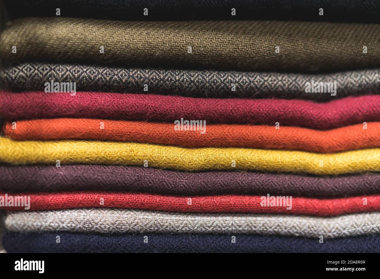close up of colorful fabric, a pile of cashmere textile, stack of ...