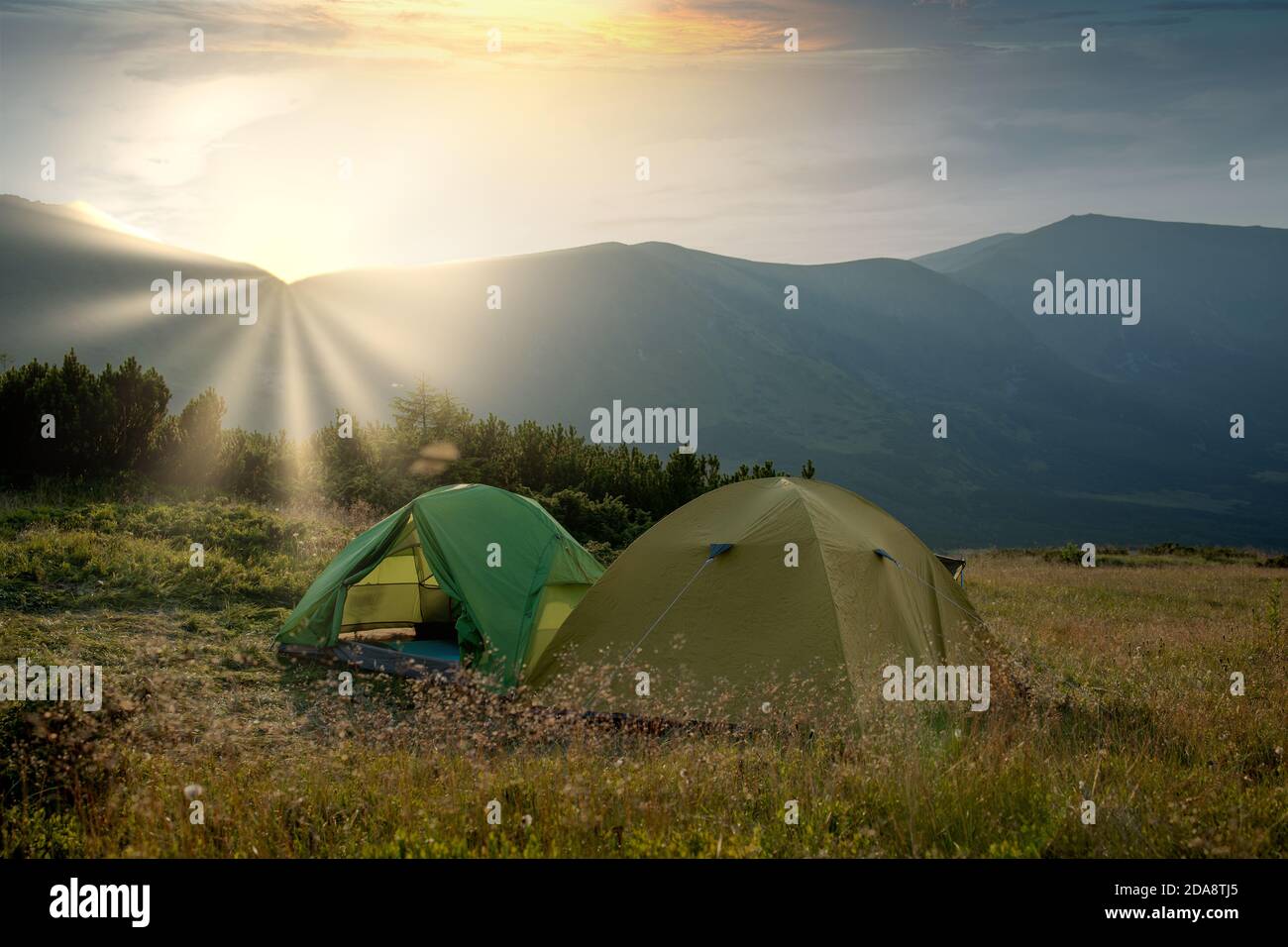 view of tourist tent in mountains at sunrise or sunset. Camping ...