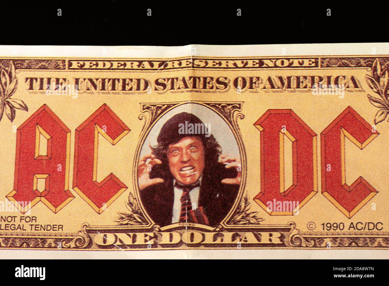 AC/DC rock band memorabilia from 1990 as a fake 1 US dollar banknote with  Angus Young face on black background Stock Photo - Alamy