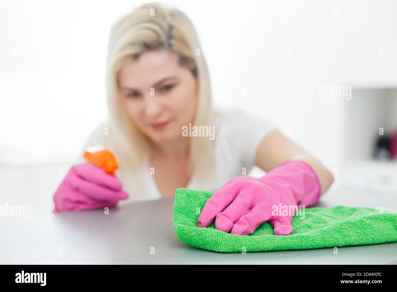 Woman cleaning dust from bookshelf. Young girl sweeping shelf, spring cleaning concept, copy