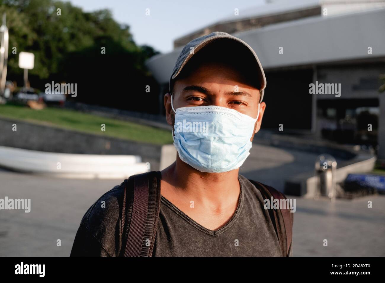 Portrait of young African man with a medical protective mask on his face at city street. Concept of preventive measures and protection for coronavirus Stock Photo