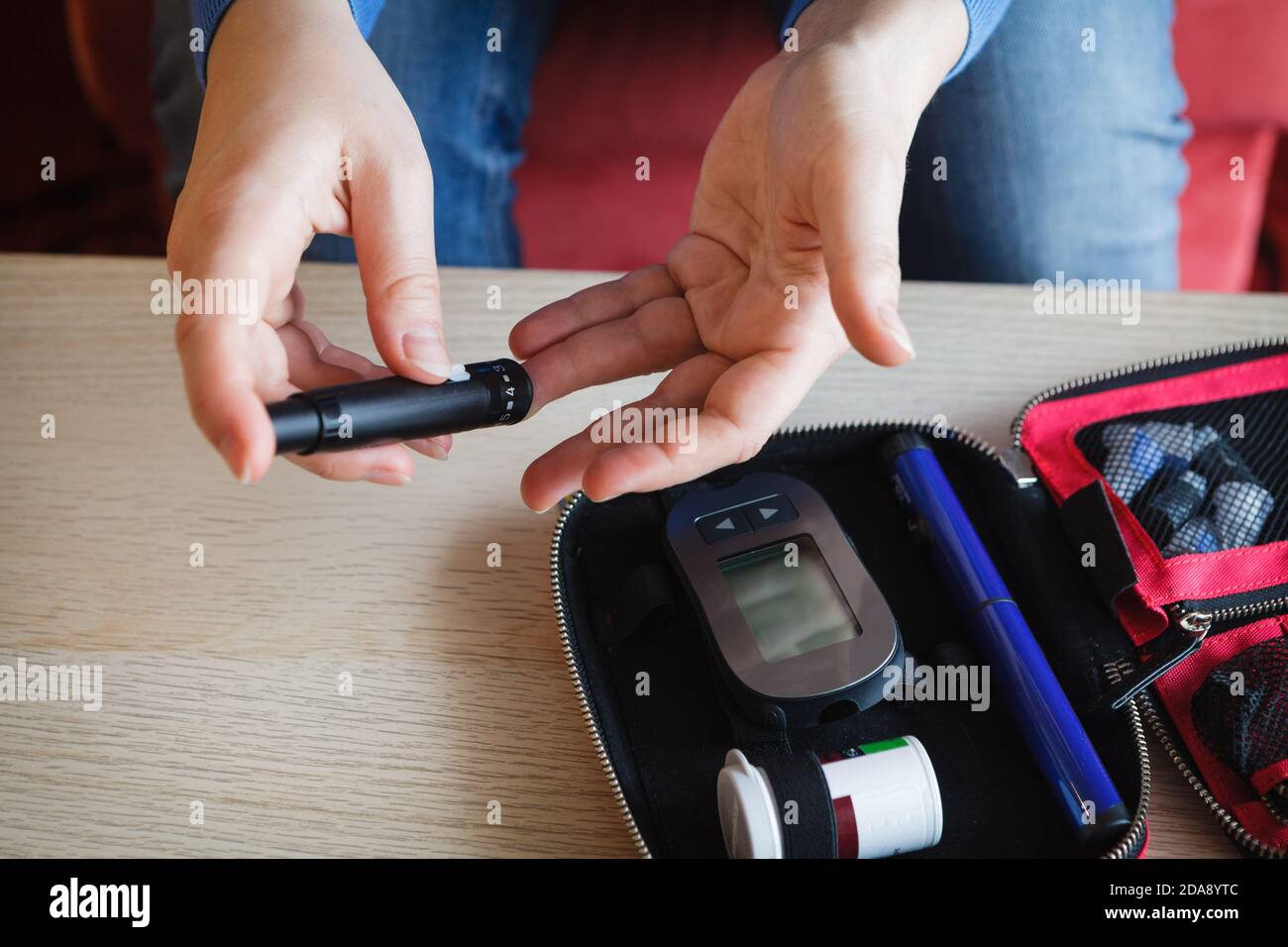 Woman checking glucose level in her blood Stock Photo