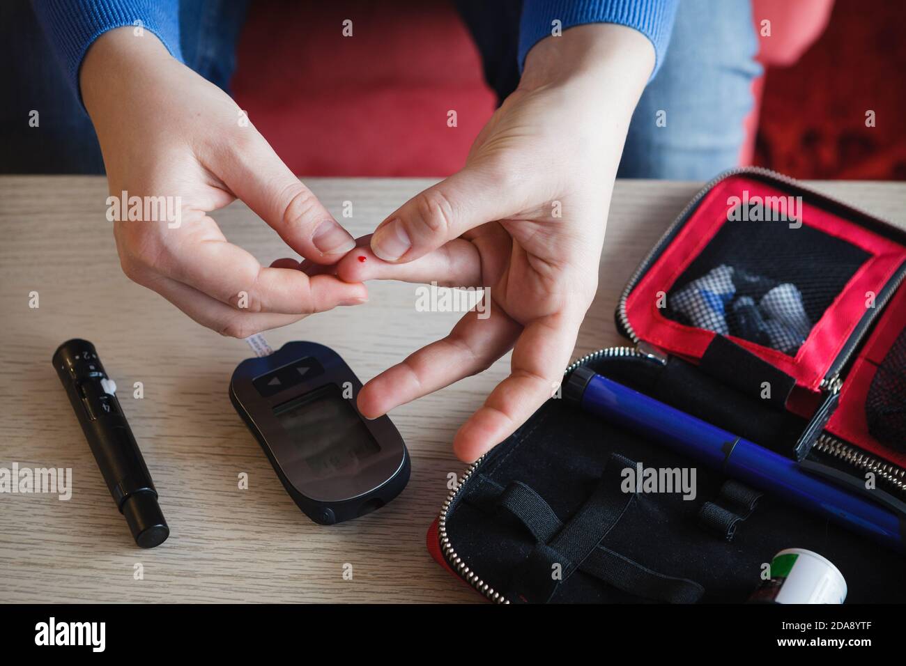 Woman checking glucose level in her blood Stock Photo