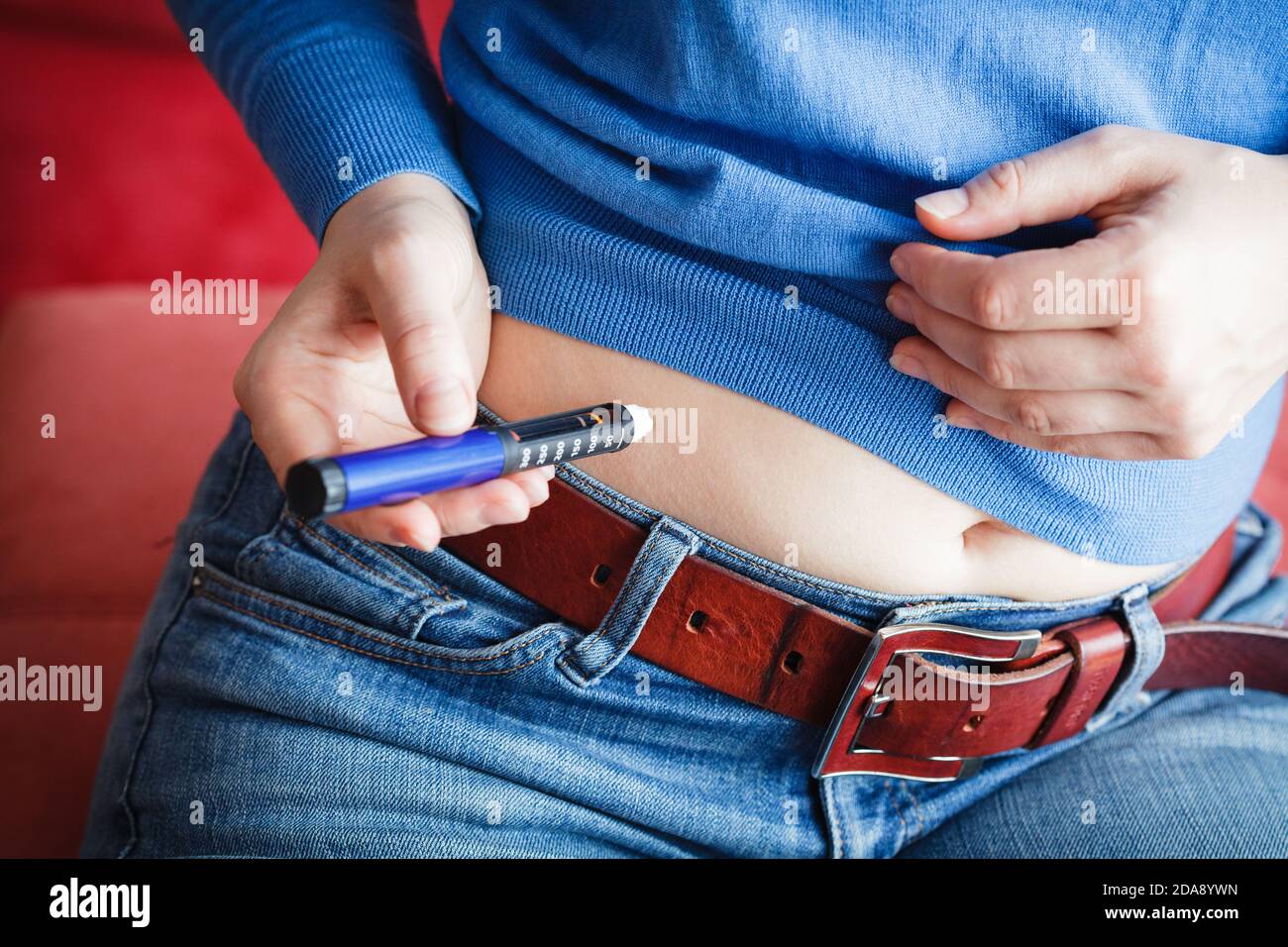 Woman is injecting insuline into her stomach Stock Photo