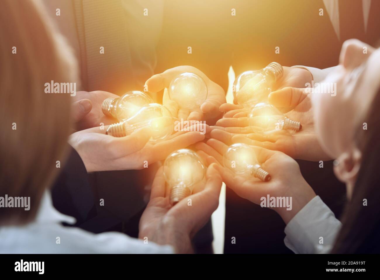 Teamwork and brainstorming concept with businessmen that share an idea with a lamp. Concept of startup Stock Photo