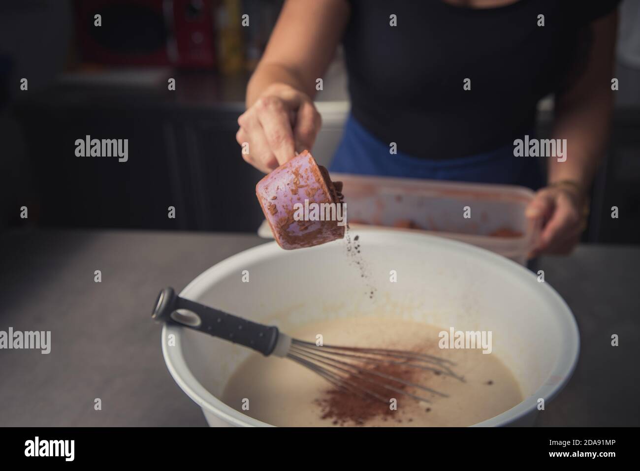 young woman making non-industrial homemade cake in small kitchen Stock Photo