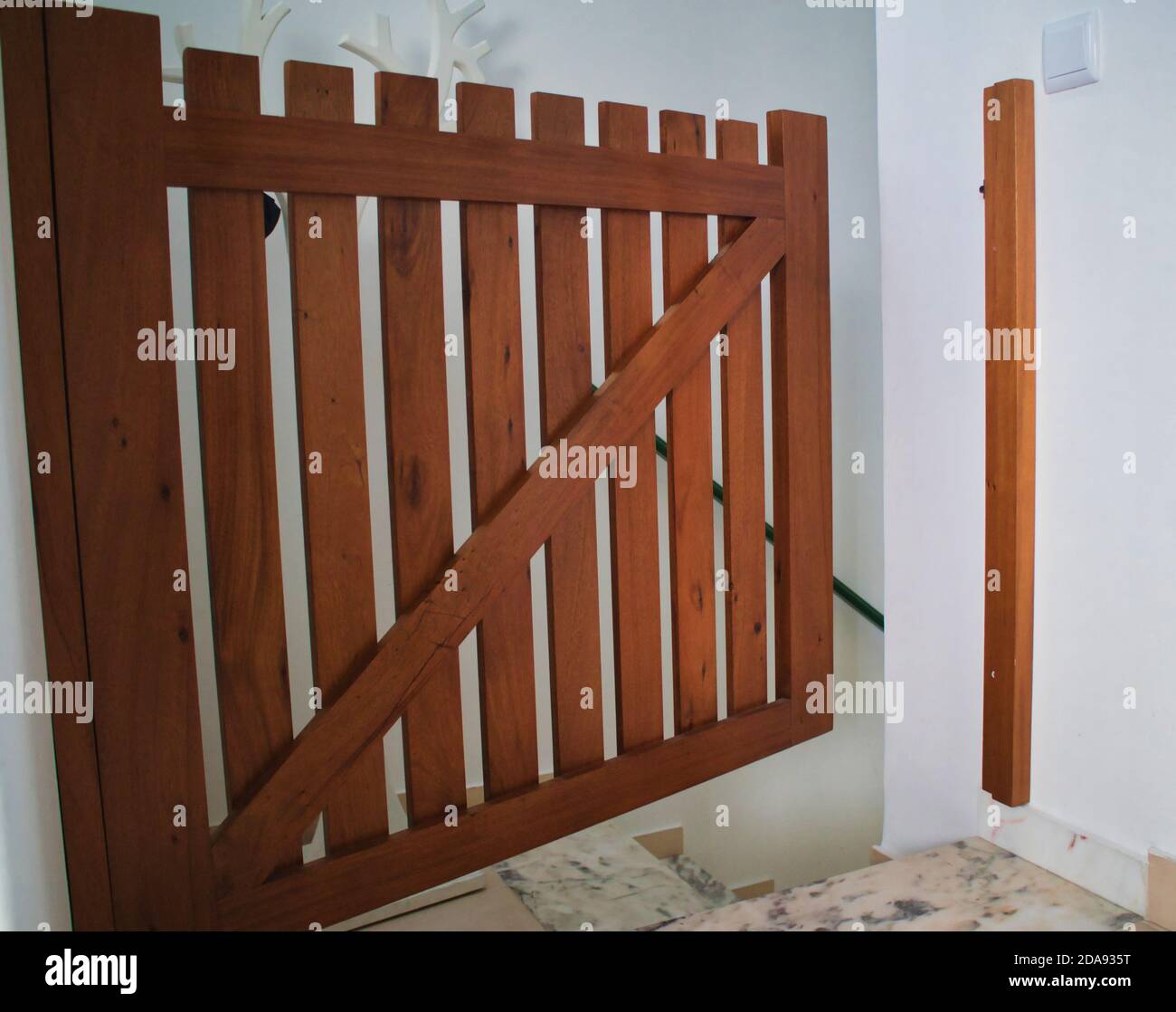 Open child safety gate at top of stairs showing danger of falling Stock Photo
