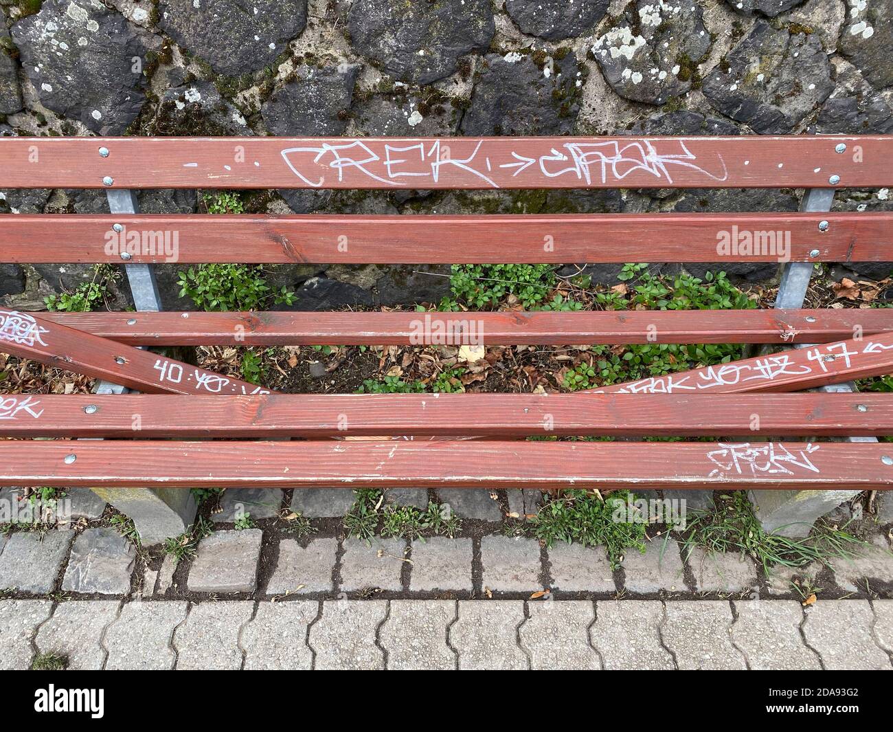 Vandalism, wilfully destroyed park bench, wooden bench, on a pavement, Duisburg, NRW, Germany Stock Photo