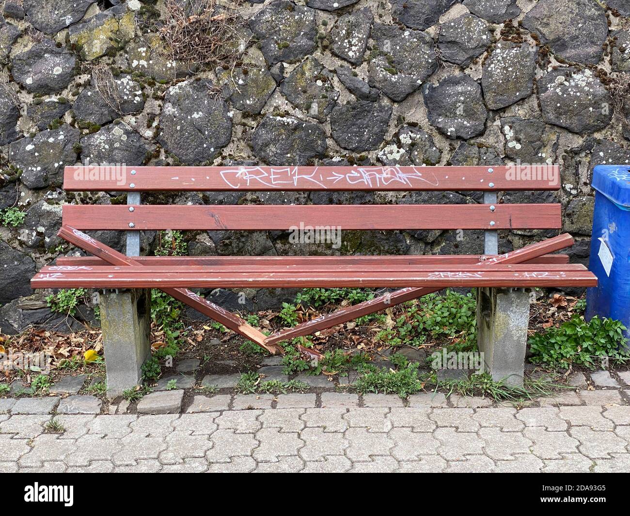Vandalism, wilfully destroyed park bench, wooden bench, on a pavement, Duisburg, NRW, Germany Stock Photo
