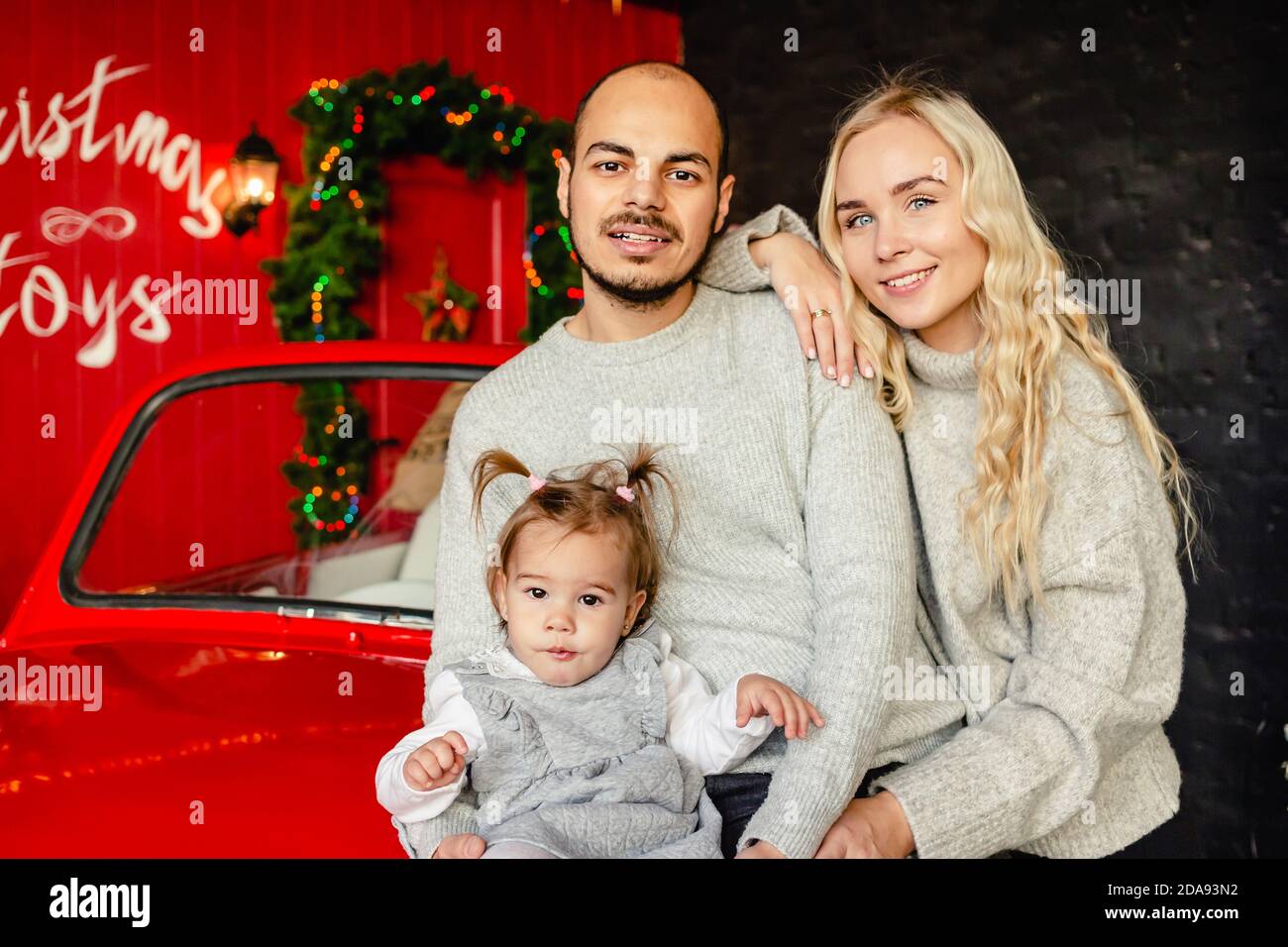 Smiling mother, father and little girl over christmas background. Copy cpace. Family, childhood, holidays and people concept. Stock Photo