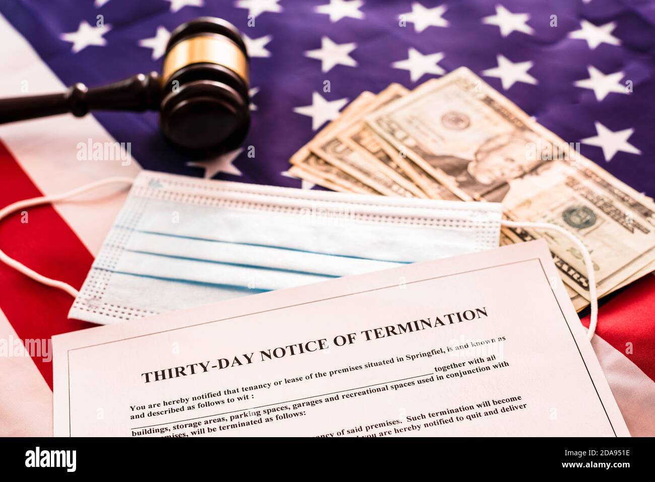 Thirty days Notice of Termination document, on the background of the American flag with dollars and hygienic masks. Stock Photo