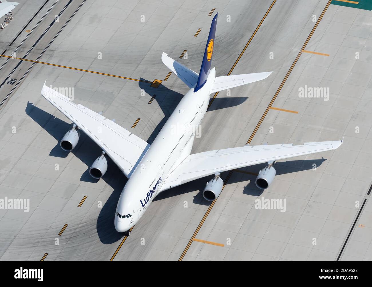 Lufthansa Airbus A380 aircraft taxiing over taxiway lines. A380-800 aeroplane of German airline aerial view. Stock Photo