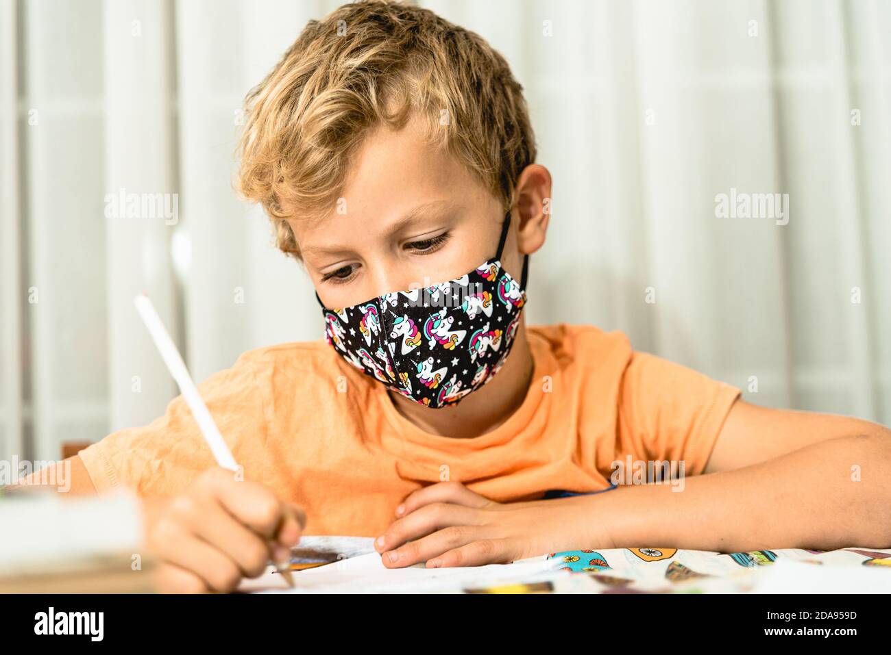 Child with mask confined at home during quarantine. Stock Photo