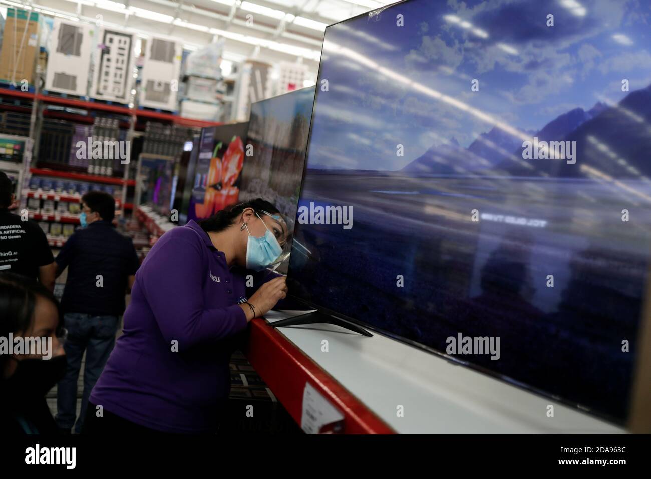 A woman looks at a television during the shopping season, 'El Buen Fin'  (The Good Weekend), at a Sam's Club store, as the coronavirus disease  (COVID-19) outbreak continues, in Mexico City, Mexico,