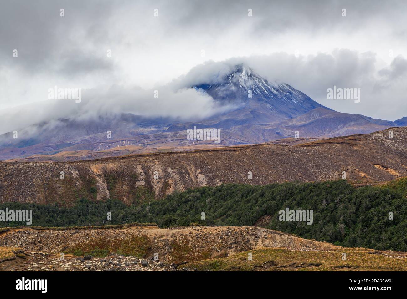 Mount Ngauruhoe in the Tongariro National Park, New Zealand. A blanket of cloud is being blown onto the mountain Stock Photo