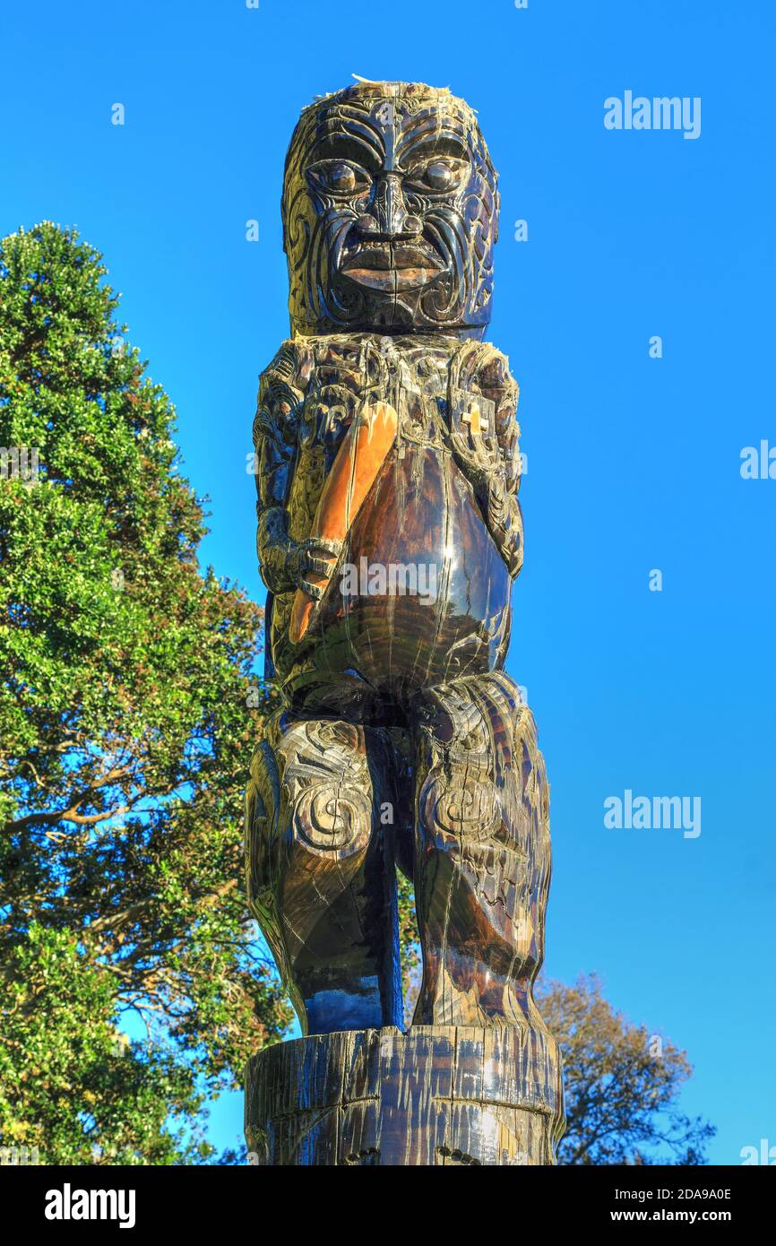 A Maori carving at Gate Pa, Tauranga, New Zealand, depicting the prophet Hakaraia Mahika holding a club and Bible Stock Photo