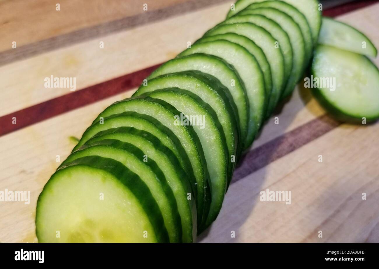 Slices of cucumber arranged on top of a cutting board Stock Photo - Alamy
