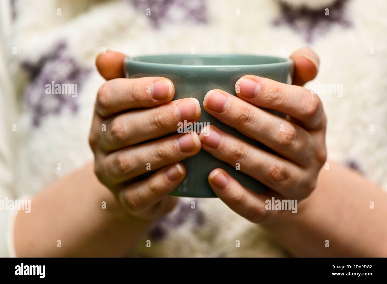 Young wooman drinking hot cocoa or coffee. Autumn or winter moody weekend, New Year and Christmas background. Lazy day, quarantine, stay home, cosy sc Stock Photo