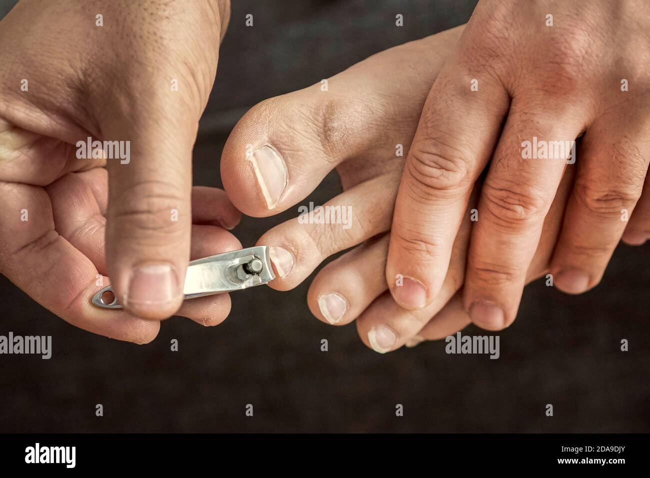 hand manicure with nail clipper. close up over black background. self-cutting  nails. close-up nail cutting Stock Photo - Alamy