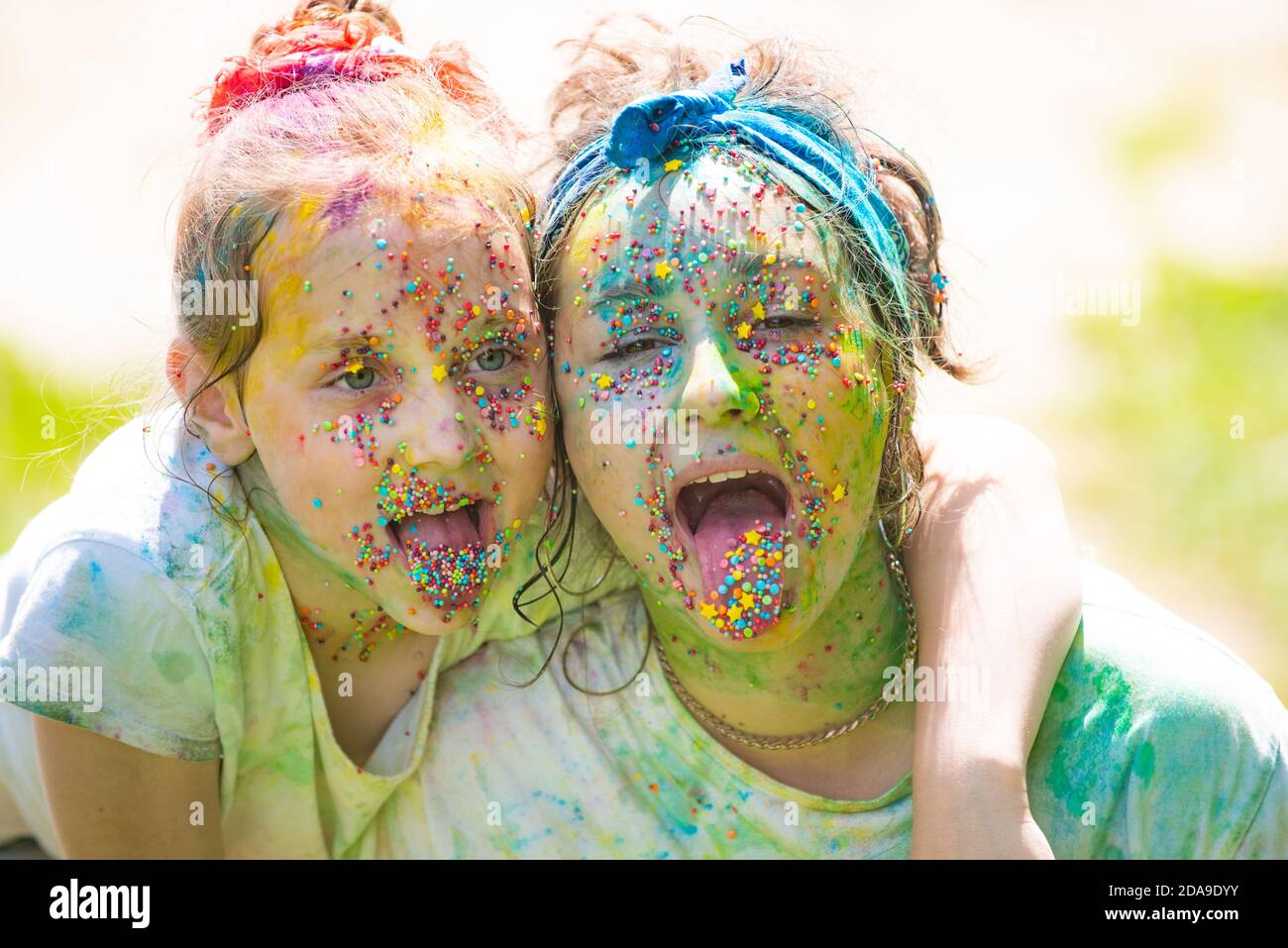 Happy childhood. Funny sisters child girls celebrate Indian holi festival  with colorful paint powder on faces Stock Photo - Alamy