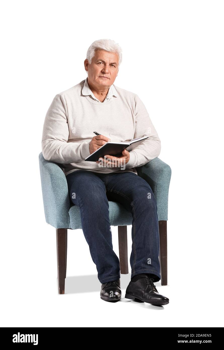 Senior male psychologist sitting in armchair on white background Stock
