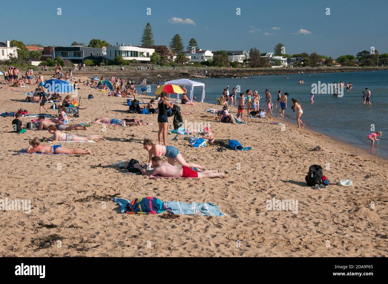 Residents crowd onto Elwood Beach on the first hot day after the lifting of strict COViD-19 lockdown restrictions in Melbourne, Victoria, Australia Stock Photo