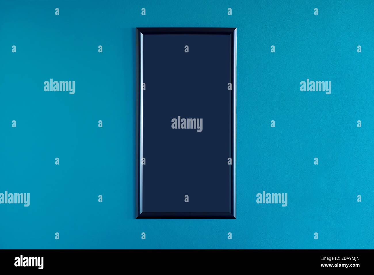 Black, narrow blank frame hanging on the interior blue wall. Empty