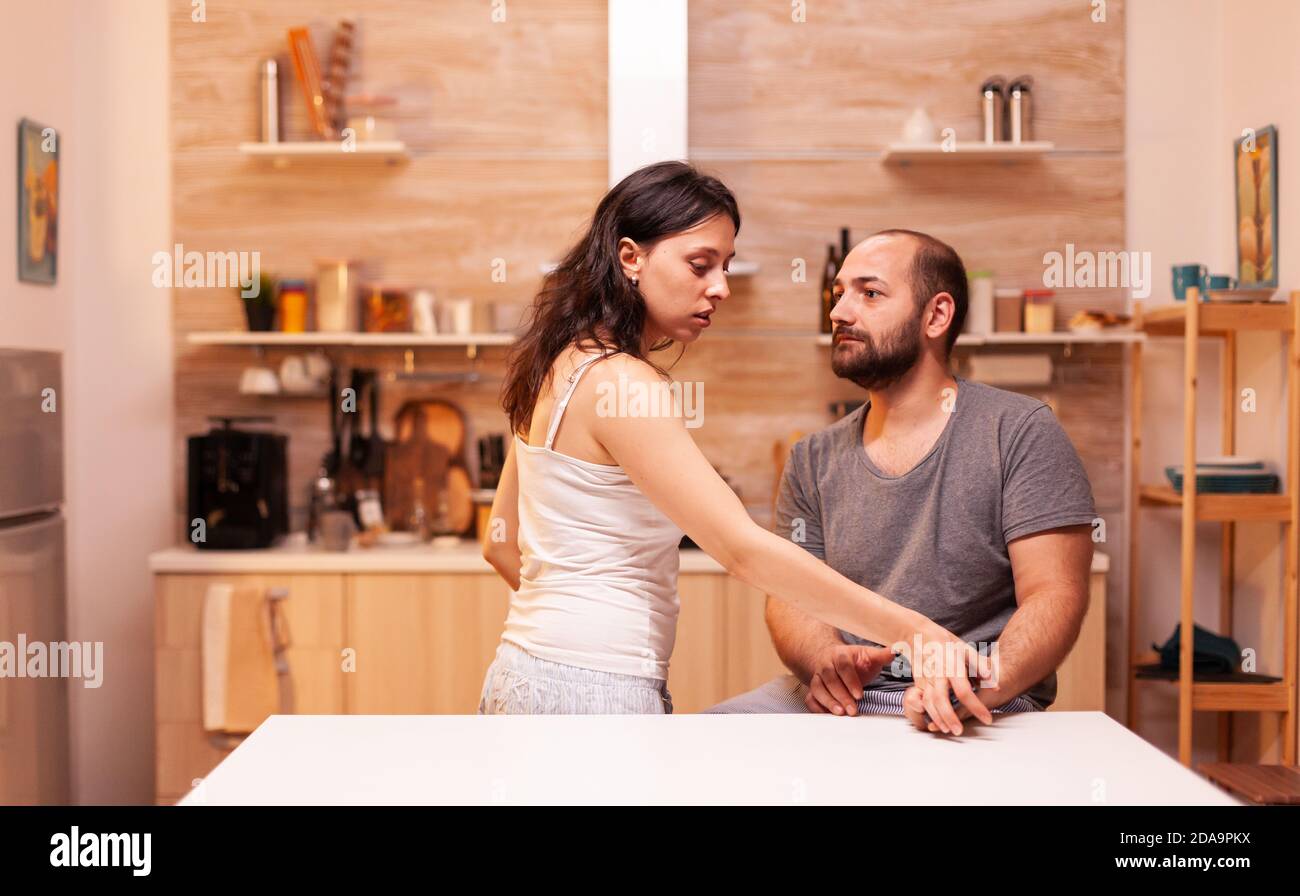 Woman having trust issues because if infidel husband and trying to read his phone messages. Heated angry frustrated offended irritated accusing her man of infidelity . Stock Photo