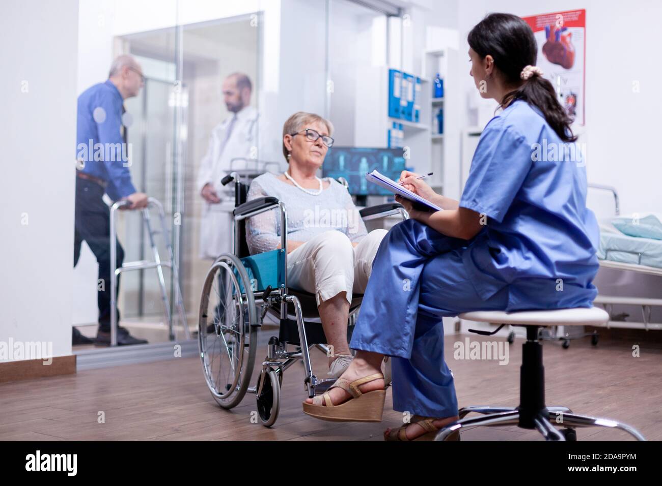 Handicapped woman in wheelchair answering nurse questionnaire during