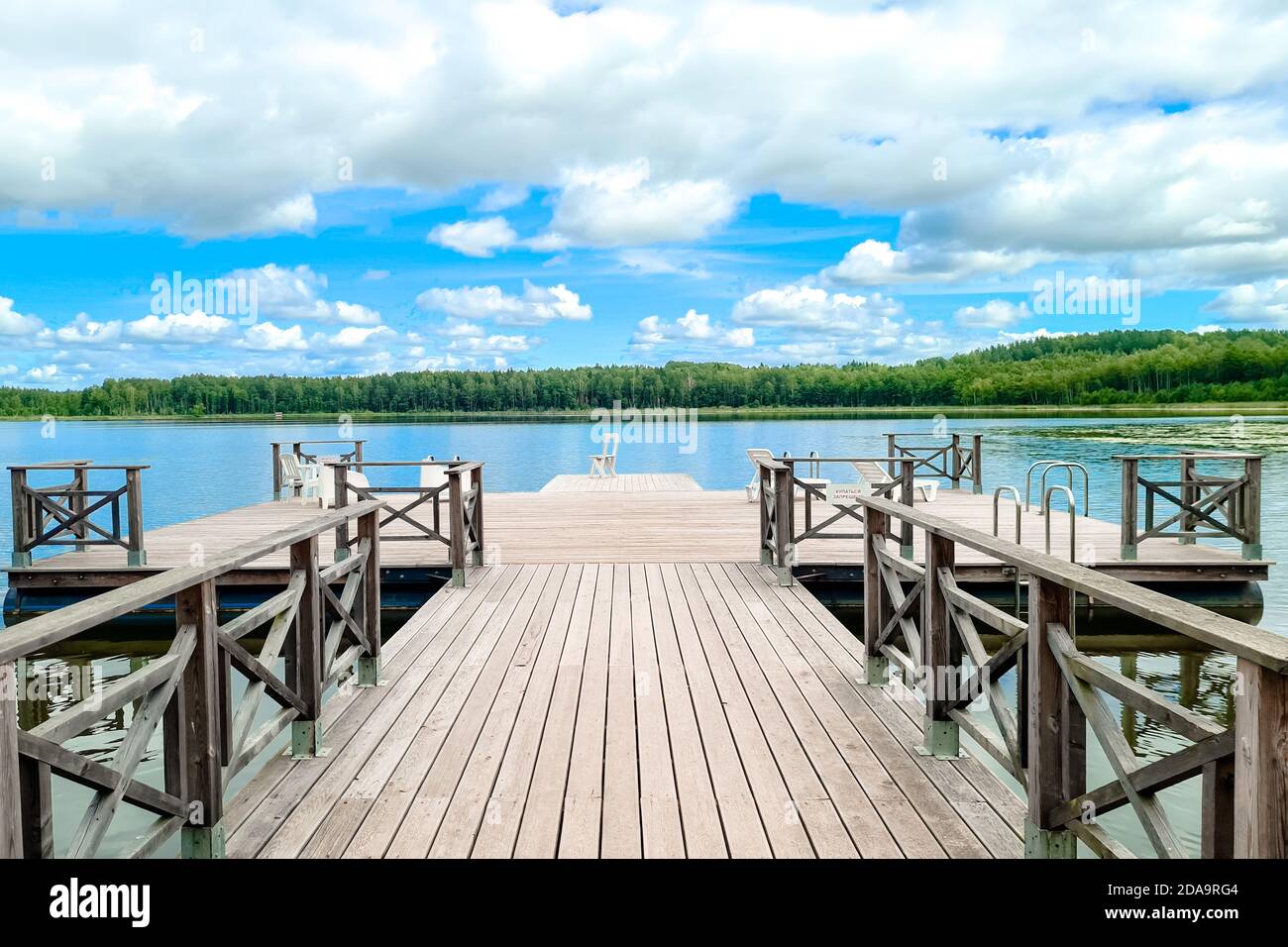 White wooden empty chair at the lake dock facing beautiful view. Stock Photo