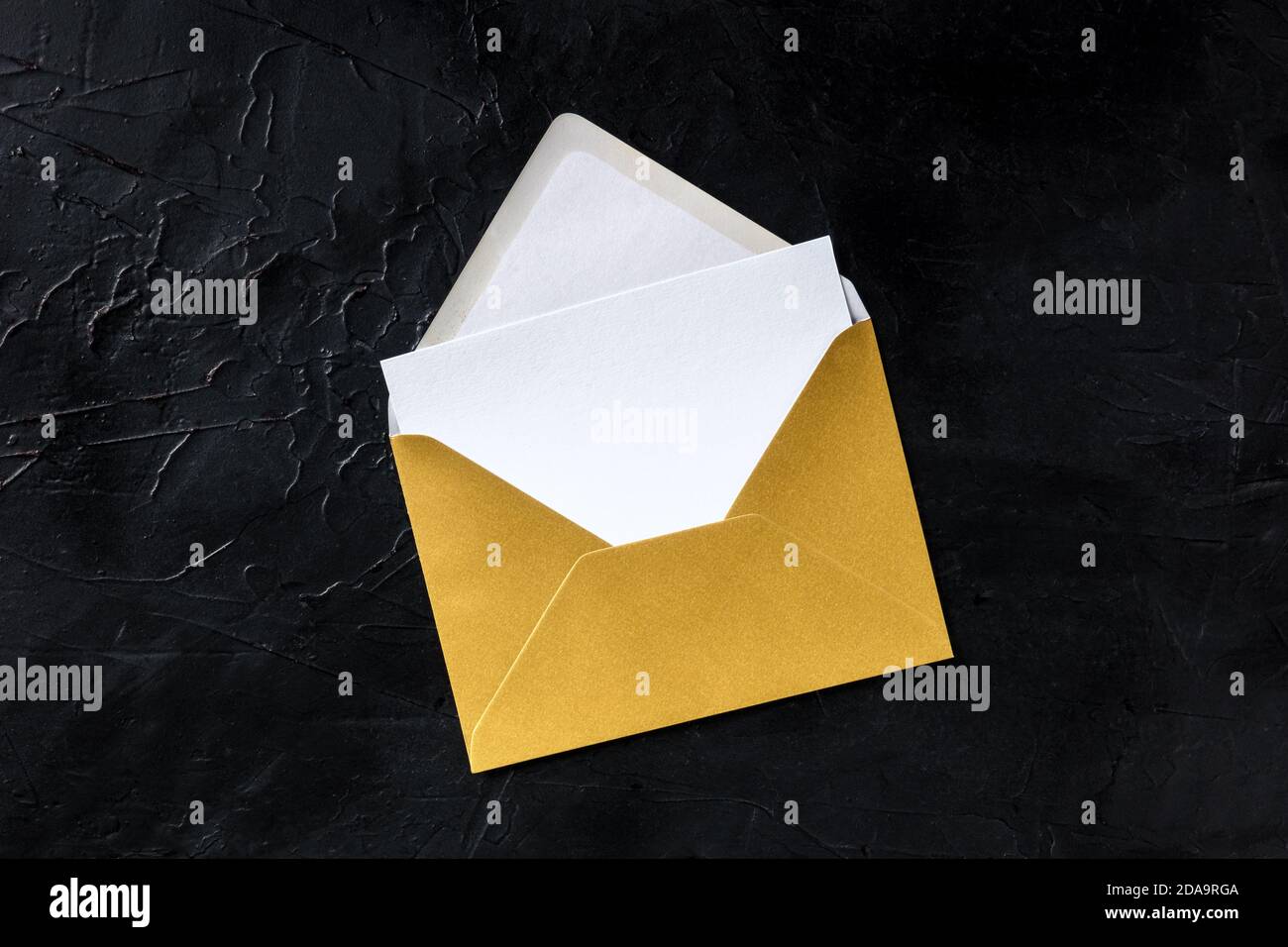 Greeting card in a golden envelope mockup, shot from above on a black ...