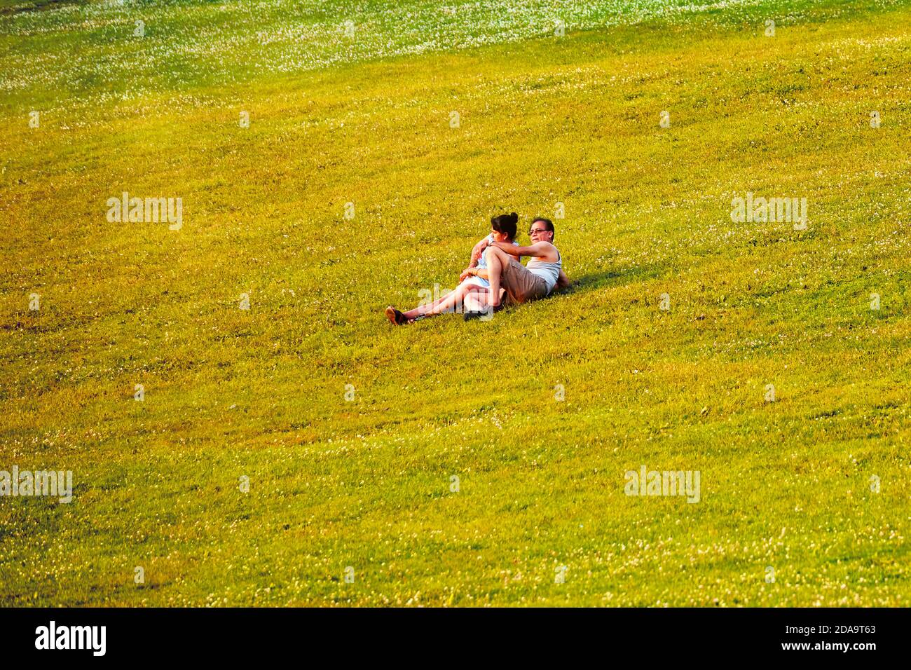 Montreal, Canada - June, 2018: Middle aged Indian couple lie down and relax on the grass in Mount Royal park in Montreal, Canada on a sunny summer aft Stock Photo