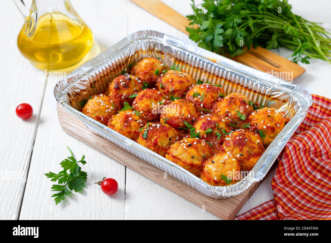 Meatballs in tomato sauce baked in an aluminum foil container. Diet