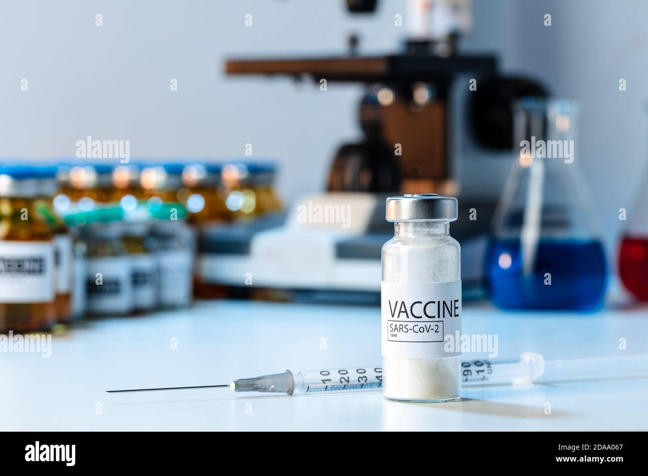 Covid-19 vaccine bottle with a syringe on lab table Stock Photo - Alamy