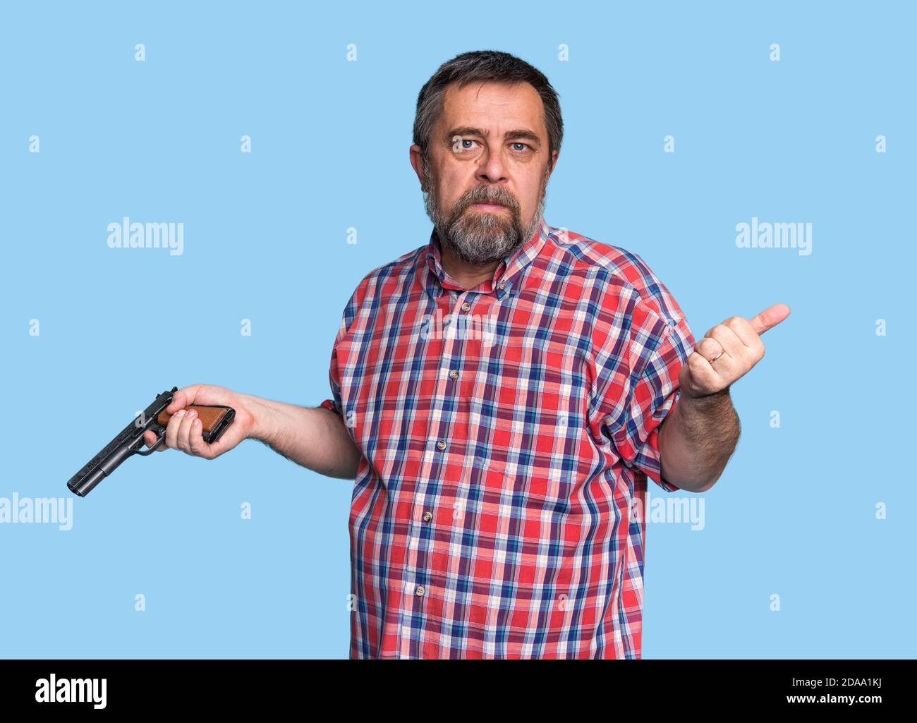 Portrait of a handsome man holding a gun. Bearded middle-aged man is ...
