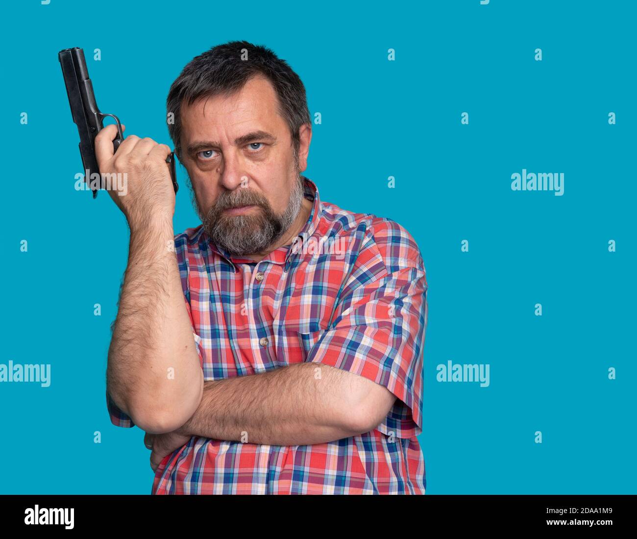 Portrait of a handsome man holding a gun. Bearded middle-aged man is ...