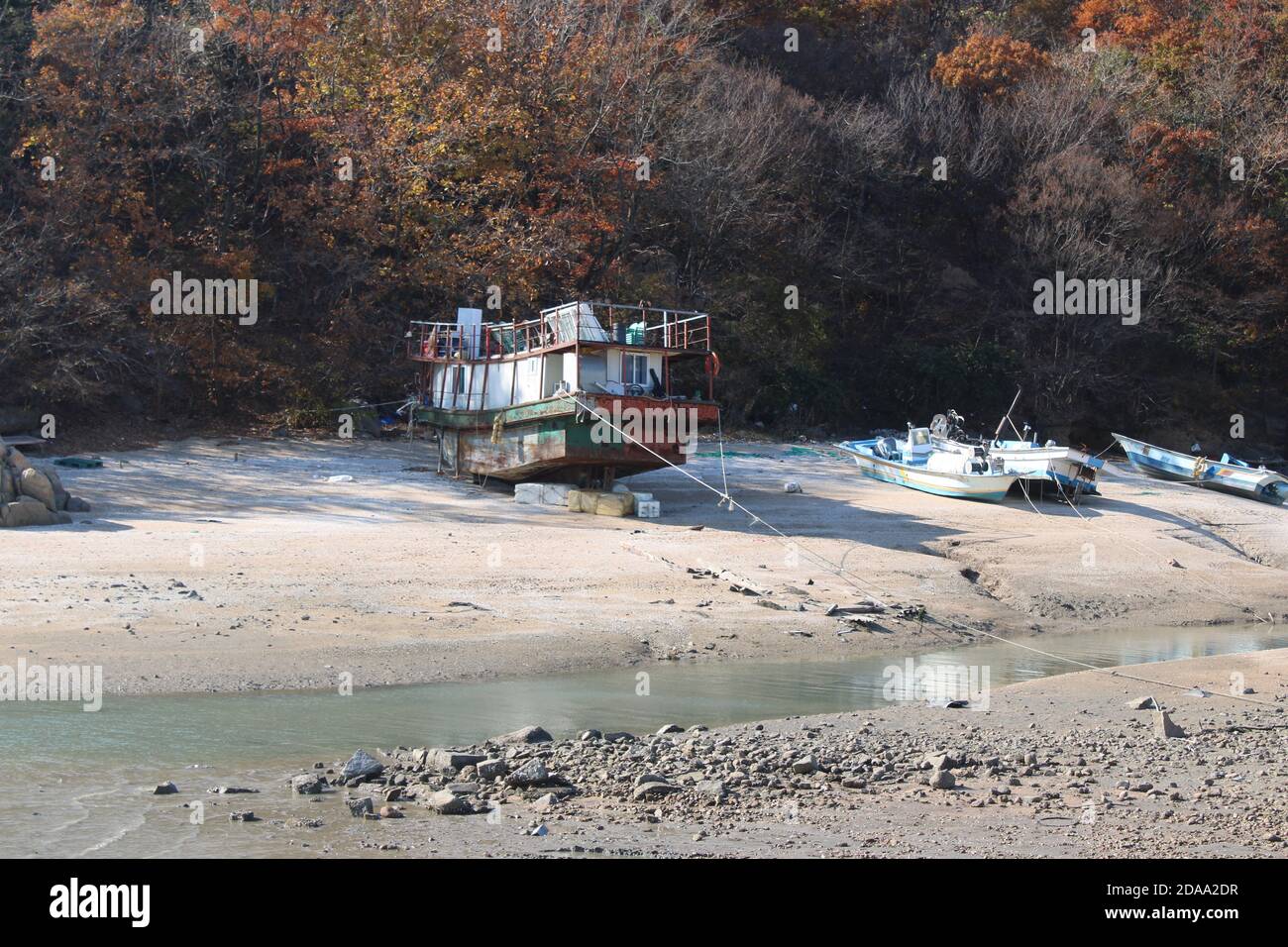 Fishing boats and an old house boat beached in low tide Stock Photo