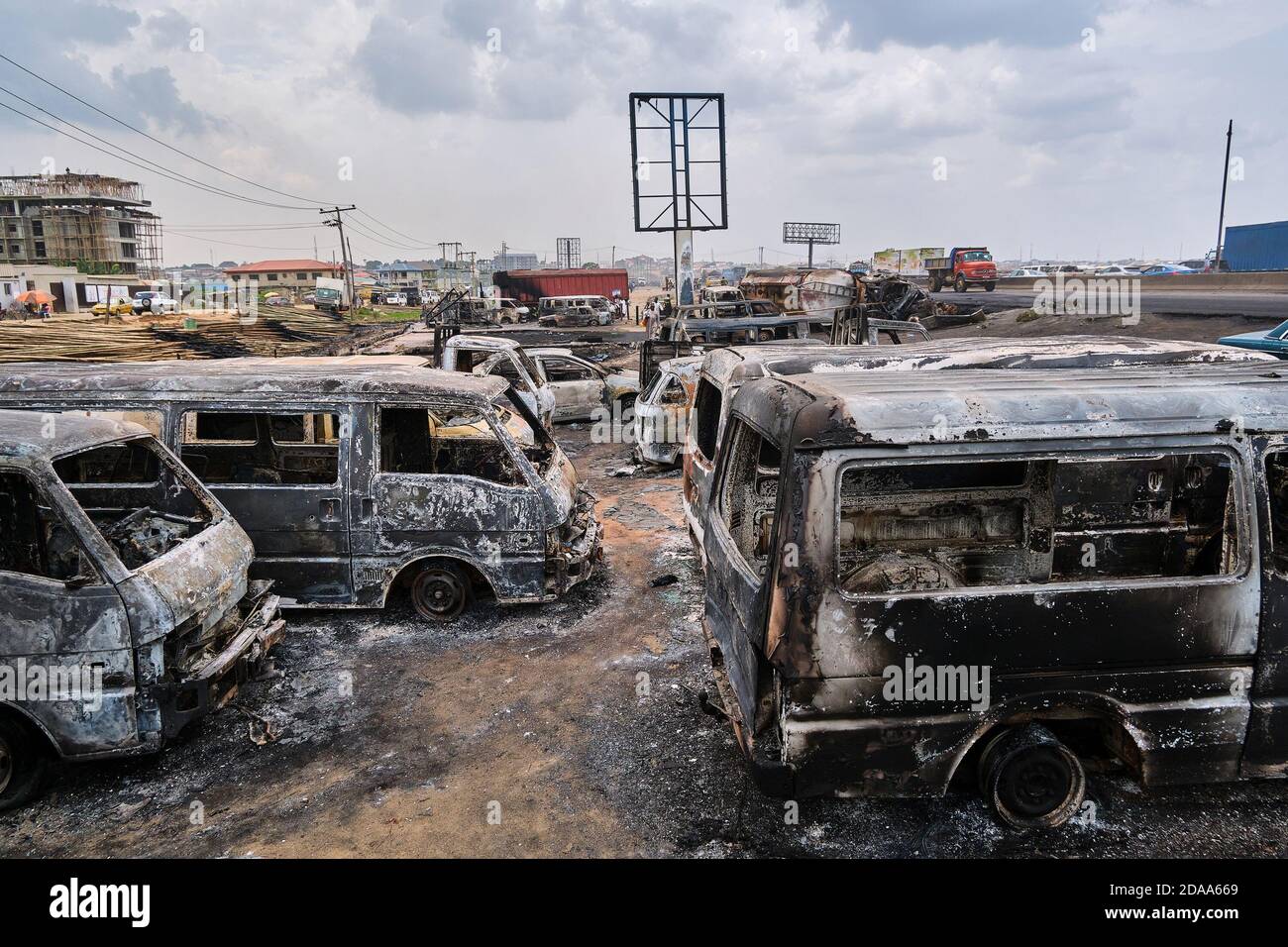 Damaged vehicles are seen at a site following an explosion after a tanker carrying fuel crashed at Kara Bridge along the Lagos-Ibadan highway. Eye-witnesses claim 3 people were burnt to death, vehicles parked at a bus station and some for sale at a lot were burnt in the accident which happened around 2am after a fuel-laden tanker exploded after losing its tires. Lagos, Nigeria. November 7, 2020. Stock Photo