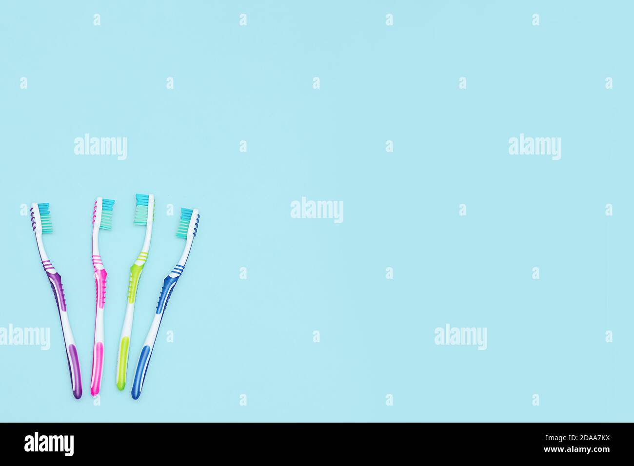 Set of tooth brushes and copy space. A group of colorful toothbrushes. Epty Space for text. Copy Space for text. Flat lay on blue background Stock Photo
