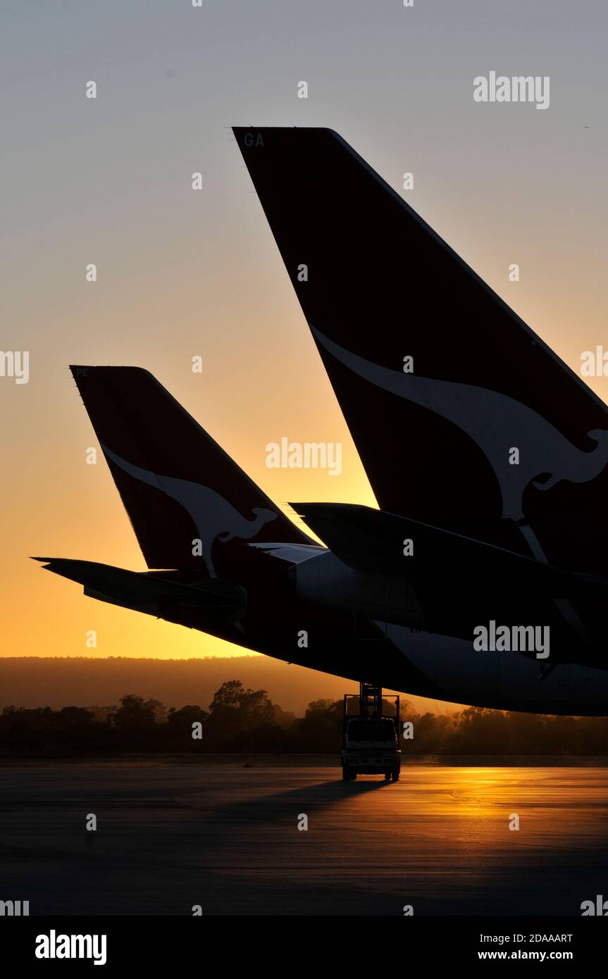 Silhouetted tails of airliners at sunset at an airport, Stock Photo