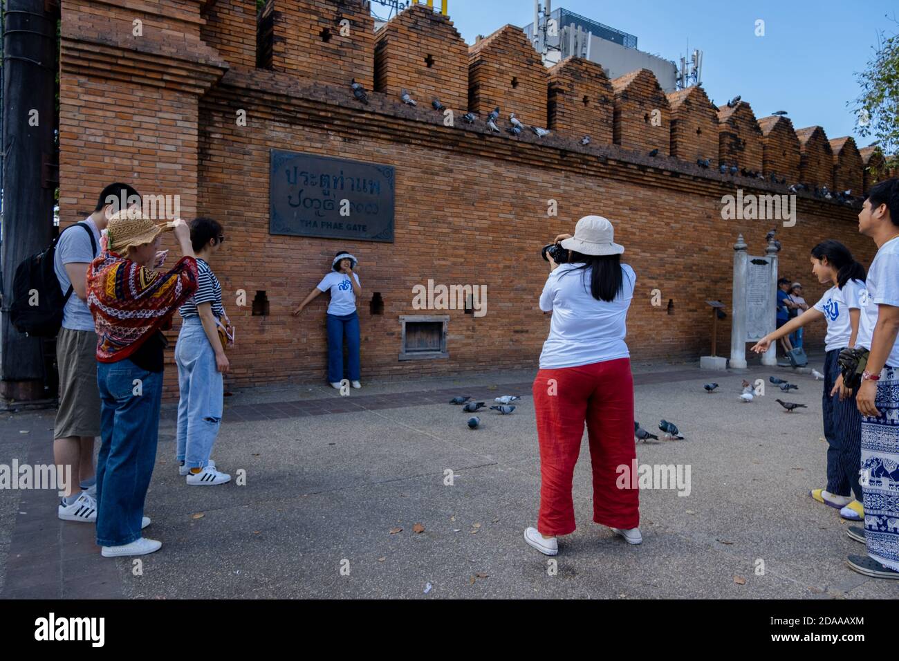Thailand; Jan 2020: Group of tourists taking pictures at the entrance of the Old Town. Ancient brick wall. Chiang Mai, Thailand, Southeast Asia Stock Photo