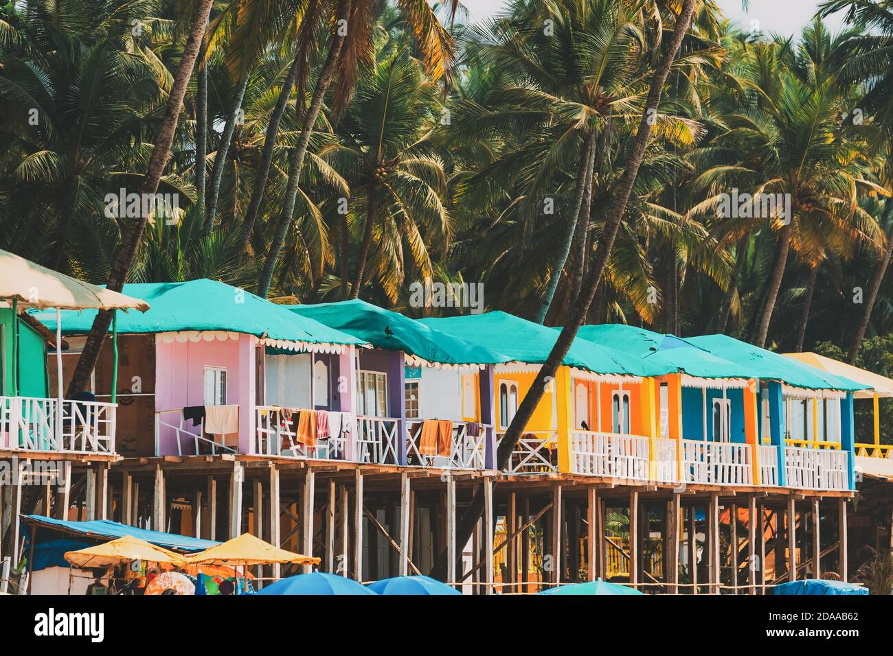 Canacona, Goa, India. Famous Painted Guest Houses On Beach Against Background Of Tall Palm Trees In Sunny Day Stock Photo