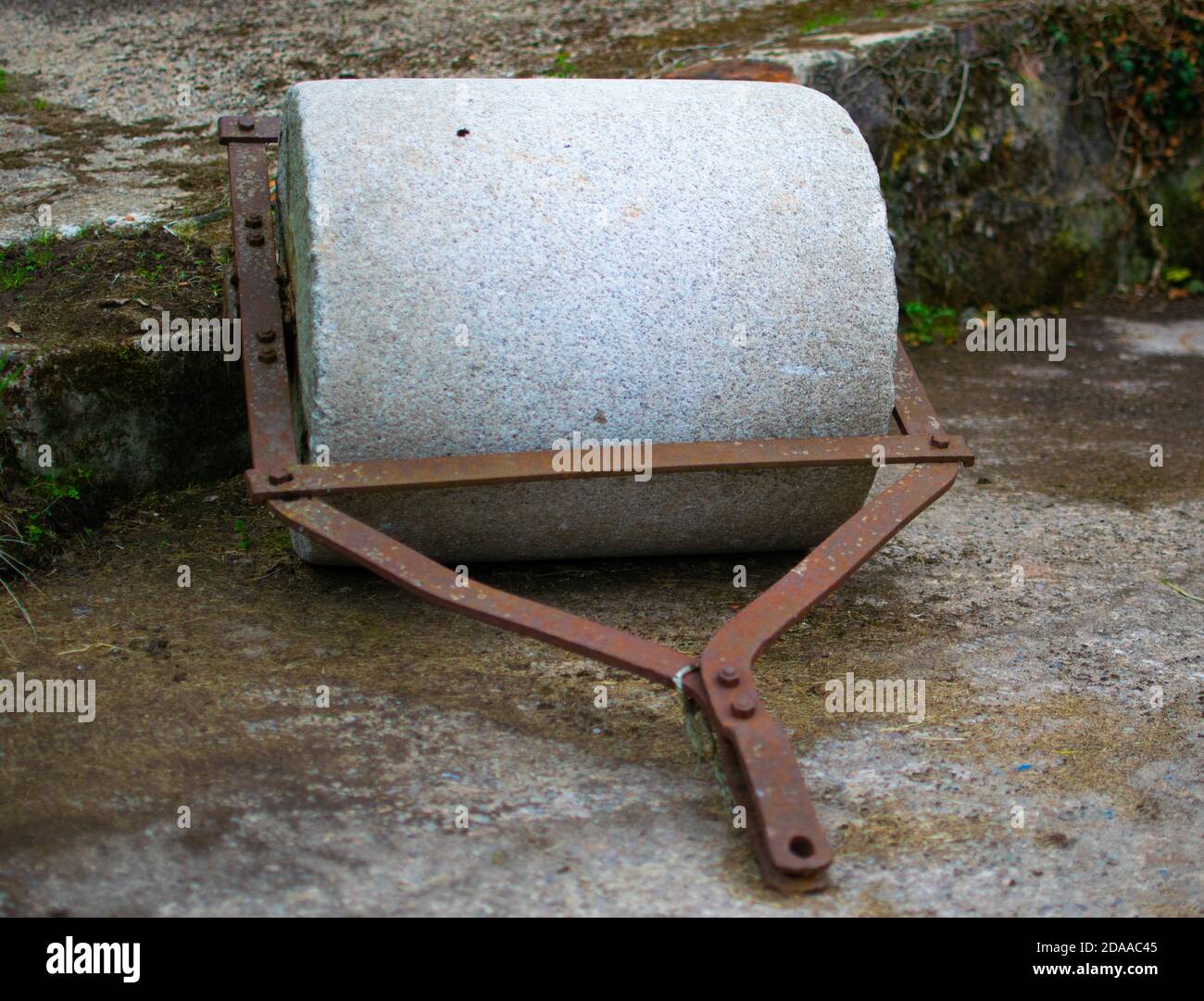 An historic granite roller on farming grounds. Stock Photo