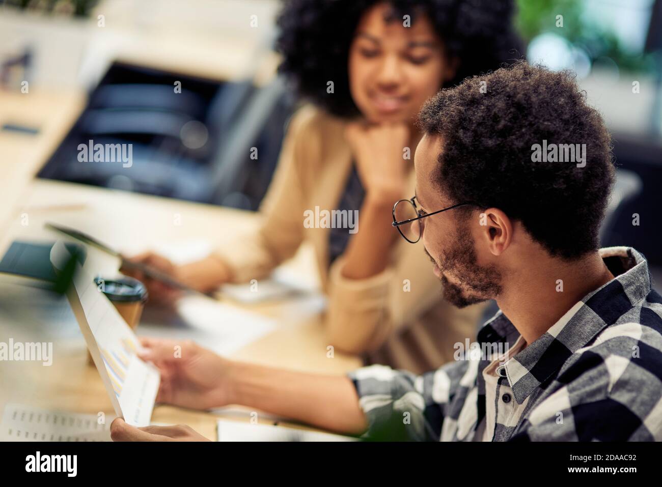 Two young diverse colleagues working together in the office. Business ...