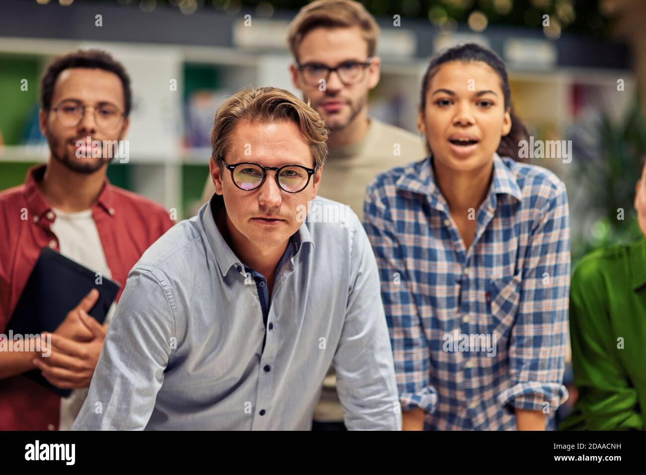 Strong team. Group of confident multiracial business people looking at camera while standing in the modern office. Collaboration and cooperation concept Stock Photo