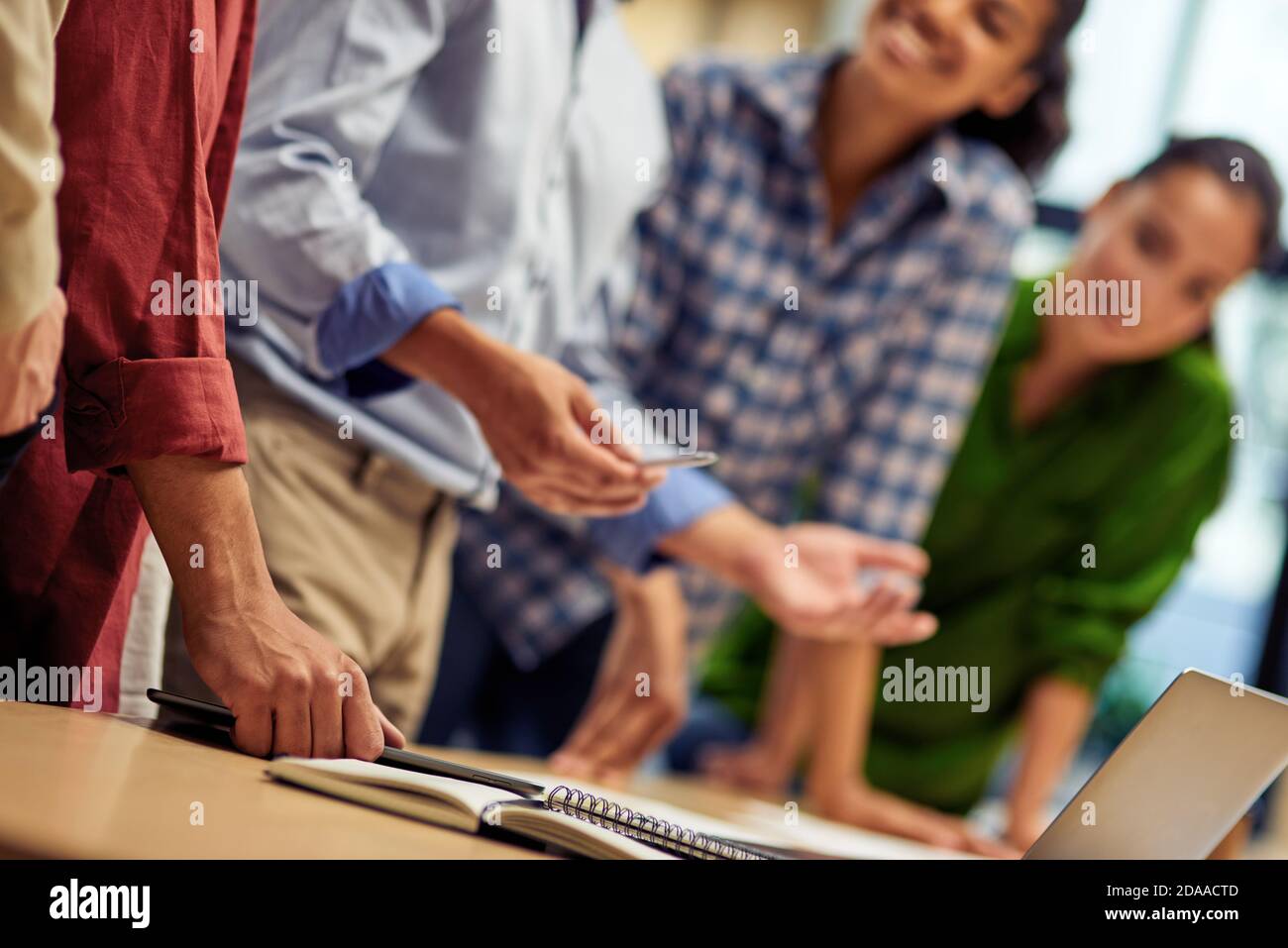 Businessman explaining something to young multiracial colleagues while working together in the office, using laptop. Business people and teamwork concept Stock Photo